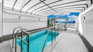 a swimming pool on a house with an awning at Yeosu The Shine Blue Pool Villa in Yeosu