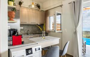 a kitchen with a counter and chairs and a window at Thyme 1 in Agia Galini