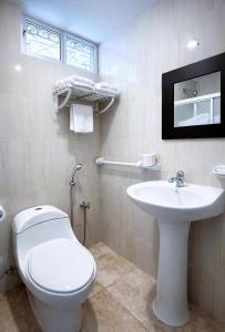 a bathroom with a white toilet and a sink at Habitaciones Sky in Manta