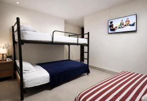 a bedroom with two bunk beds and a tv at Habitaciones Sky in Manta