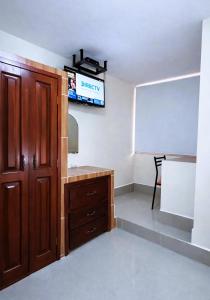 a room with a desk and a tv on the wall at Habitaciones Sky in Manta