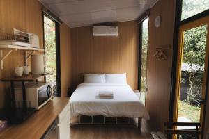 a bedroom with a bed in a small room with windows at Pinelight Retreat in Kuei-chu-lin