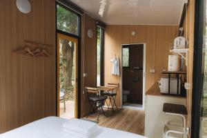 a room with a bed and a kitchen with a table at Pinelight Retreat in Kuei-chu-lin