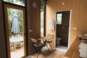 a room with a table and chairs and a bathroom at Pinelight Retreat in Kuei-chu-lin