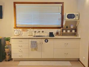 a kitchen with a sink and a microwave at 12 apostles cottages in Princetown