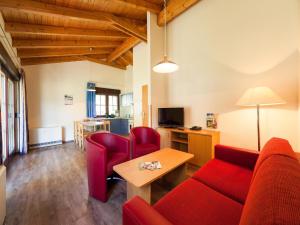 a living room with a red couch and a table at Ferienhaus im Trixi Ferienpark in Großschönau