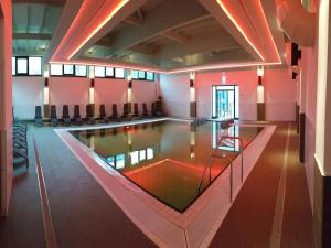 a swimming pool in a building with red walls at Ferienhaus im Trixi Ferienpark in Großschönau