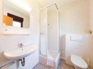 a white bathroom with a sink and a shower at Ferienhaus im Trixi Ferienpark in Großschönau +16 photos