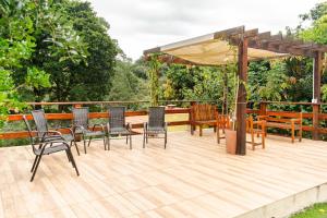 a deck with chairs and a table and an umbrella at Chácara lar e paz Mairinque in Mairinque