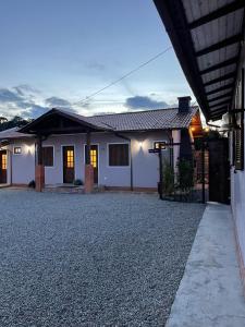 a house with a gravel driveway in front of it at Sentiero Lofts in Urubici