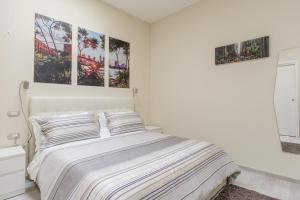 ナポリにあるモッラズ ホームの白いベッドルーム1室(壁に2枚の写真が飾られたベッド1台付)