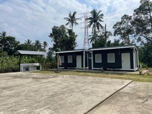 a small house in a lot with a parking lot at Casadana Riverview in Kampong Gemuroh