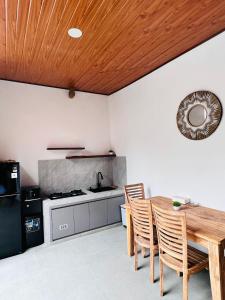 a kitchen with a table and chairs and a stove at Sedana Pertiwi House in Ubud