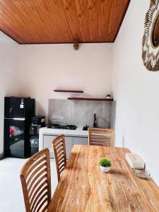 a kitchen with a wooden table with chairs and a stove at Sedana Pertiwi House in Ubud +1 photo