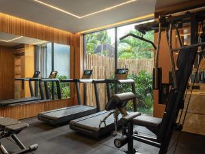 a gym with several tread machines and a large window at Alaya Suites Ubud in Ubud