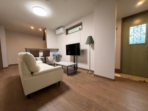 a living room with a white couch and a tv at Private house 海Kai in Nagato