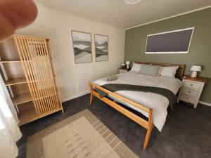 a bedroom with a bed and a book shelf at Queen's Landing in Nelson