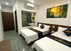 a hotel room with two beds and a bathroom at Moonknight 2Hotel in Sầm Sơn