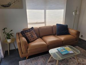 a brown couch in a living room with a table at Queen's Landing in Nelson