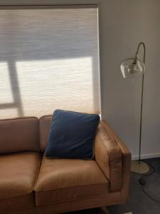 a brown couch with a blue pillow on top of it at Queen's Landing in Nelson +16 photos