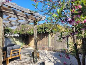 a wooden pergola in a yard with a bench at Queen's Landing in Nelson
