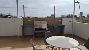a table and chairs on a balcony with a laptop at Estadía San Vicente in San Vicente de Cañete