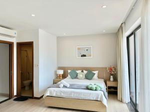 a bedroom with a bed with green pillows at Resort royal lotus Ha Long in Ha Long +15 photos