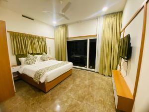 a bedroom with a bed and a flat screen tv at Misty Glen in Vagamon +2 photos