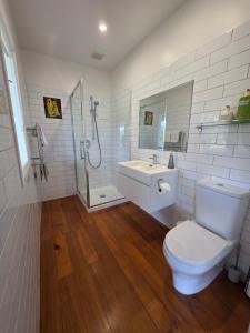 a bathroom with a toilet and a sink and a shower at Kingfisher Lodge Waterfront Retreat in Tairua +60 photos
