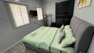 a bedroom with a bed with green sheets and pillows at Casadana Riverview in Kampong Gemuroh