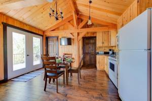 a kitchen with a table and chairs and a refrigerator at Le Huard - Lakefront & Private Dock in Sayabec