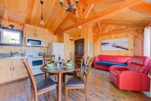 a kitchen and living room with a table and chairs at Le Huard - Lakefront & Private Dock in Sayabec +19 photos