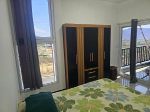 a bedroom with a bed and a dresser and two windows at Modern AC Excellent location in Los Jocotes