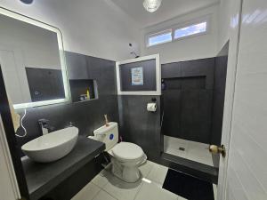 a bathroom with a white toilet and a sink at Modern AC Excellent location in Los Jocotes +15 photos