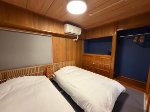 a small room with two beds and a window at Kokusai Towns Inn in Naha