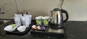 a coffee maker sitting on a counter with snacks at IRIS urban stay in Cochin +15 photos