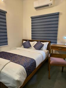 a bedroom with a bed and a table and a desk at IRIS urban stay in Cochin