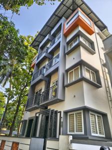 an apartment building with balconies and trees at IRIS urban stay in Cochin