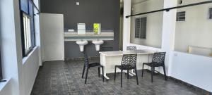a kitchen with three chairs and a table and a counter at IRIS urban stay in Cochin