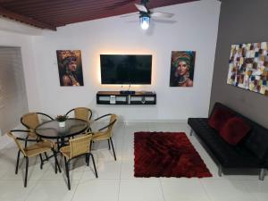 a living room with a table and chairs and a tv at Casa Terraza in El Zaino