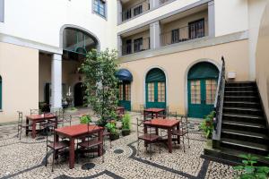 a courtyard with tables and chairs in front of a building at Hotel Monterey Nagasaki in Nagasaki