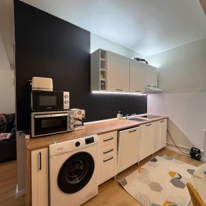 a kitchen with a washing machine and a microwave at Ap DoDe Predeal in Predeal