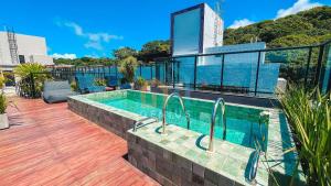 a swimming pool on top of a building at Áurea Bauten Cabo Branco Genius Flats in João Pessoa