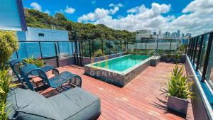 a balcony with a swimming pool on top of a building at Áurea Bauten Cabo Branco Genius Flats in João Pessoa