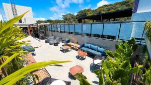 a building with a patio with blue couches and tables at Áurea Bauten Cabo Branco Genius Flats in João Pessoa
