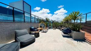 a patio with couches and chairs on a building at Áurea Bauten Cabo Branco Genius Flats in João Pessoa +16 photos
