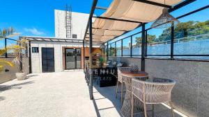 a patio with a table and chairs and some water at Áurea Bauten Cabo Branco Genius Flats in João Pessoa
