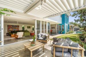 an outdoor living room with a white pergola at Beachside Banksia in East Ballina