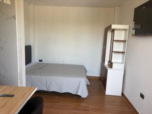a small room with a bed and a book shelf at Estadía San Vicente in San Vicente de Cañete