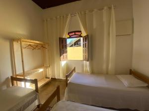 a bedroom with two beds and a window at Casa para a temporada com 3 quartos a caminho do centro in Porto Seguro